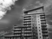 现代高层公寓楼的单色照片，天空富有动感