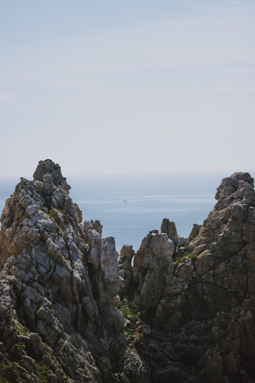 Spectacular landscape of rough mountain and calm sea under blue cloudless sky on sunny day