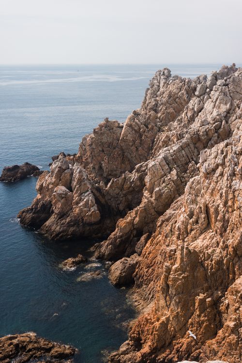 Free Spectacular scenery of rocky cliff near blue water of calm sea on sunny day Stock Photo