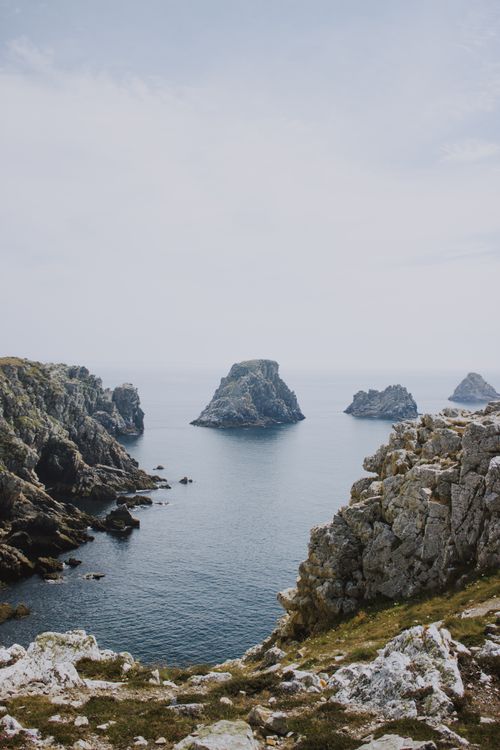 Free Breathtaking scenery of seascape with rough rocks and green grass under gray sky Stock Photo