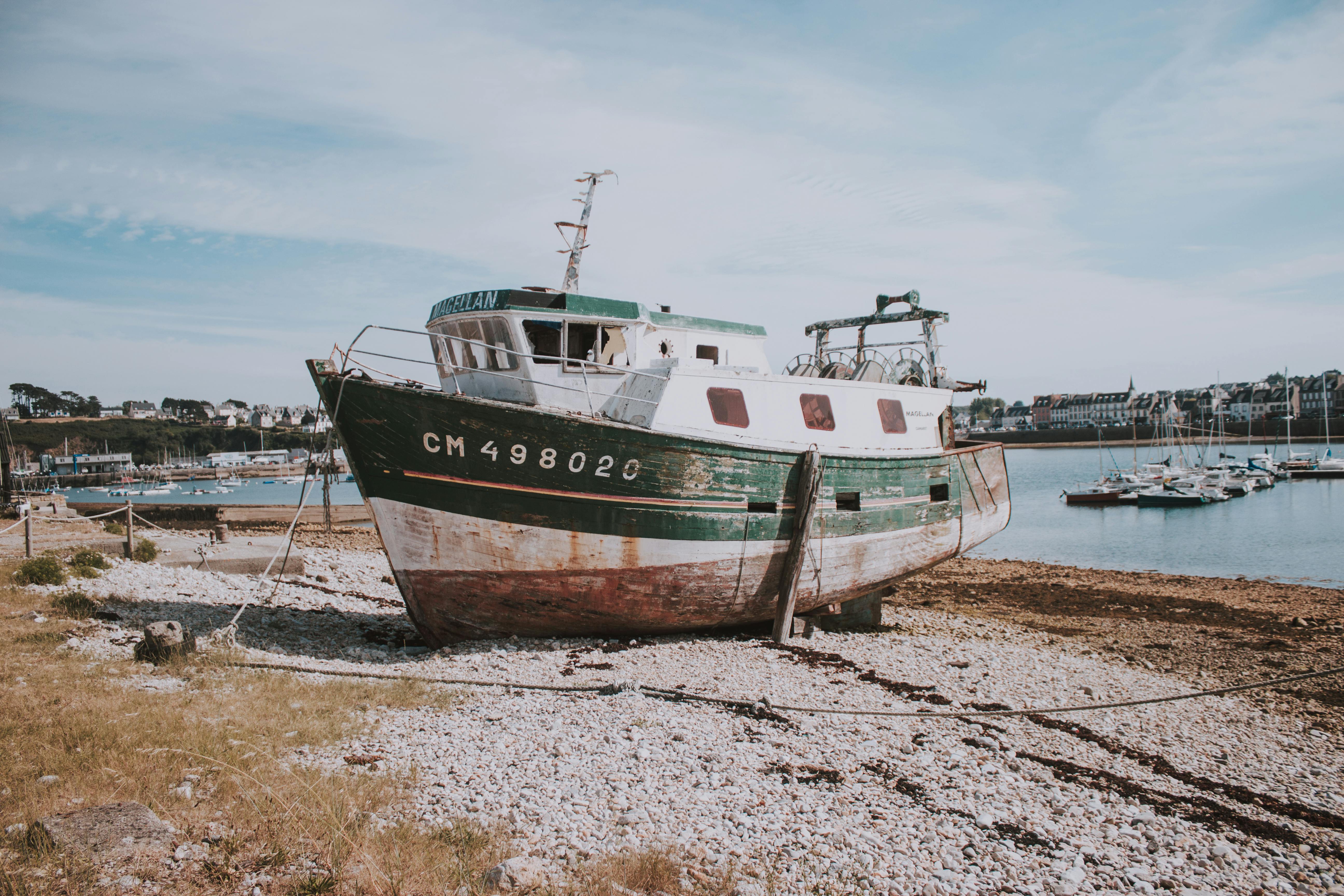 Rusty ship on seashore in harbor · Free Stock Photo