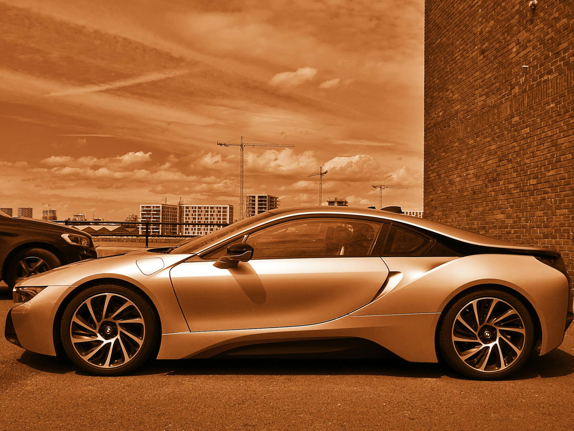 Sleek luxury sports car parked outdoors, highlighted in sepia tone for an artistic touch.