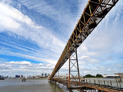 Brown Steel Bridge Under Cloudy Sky