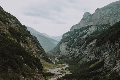 Mountainous terrain under gray cloudy sky