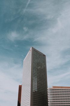 在阳光明媚的日子里，现代城市市中心的高几何摩天大楼低角度与玻璃镜面窗户相映成趣