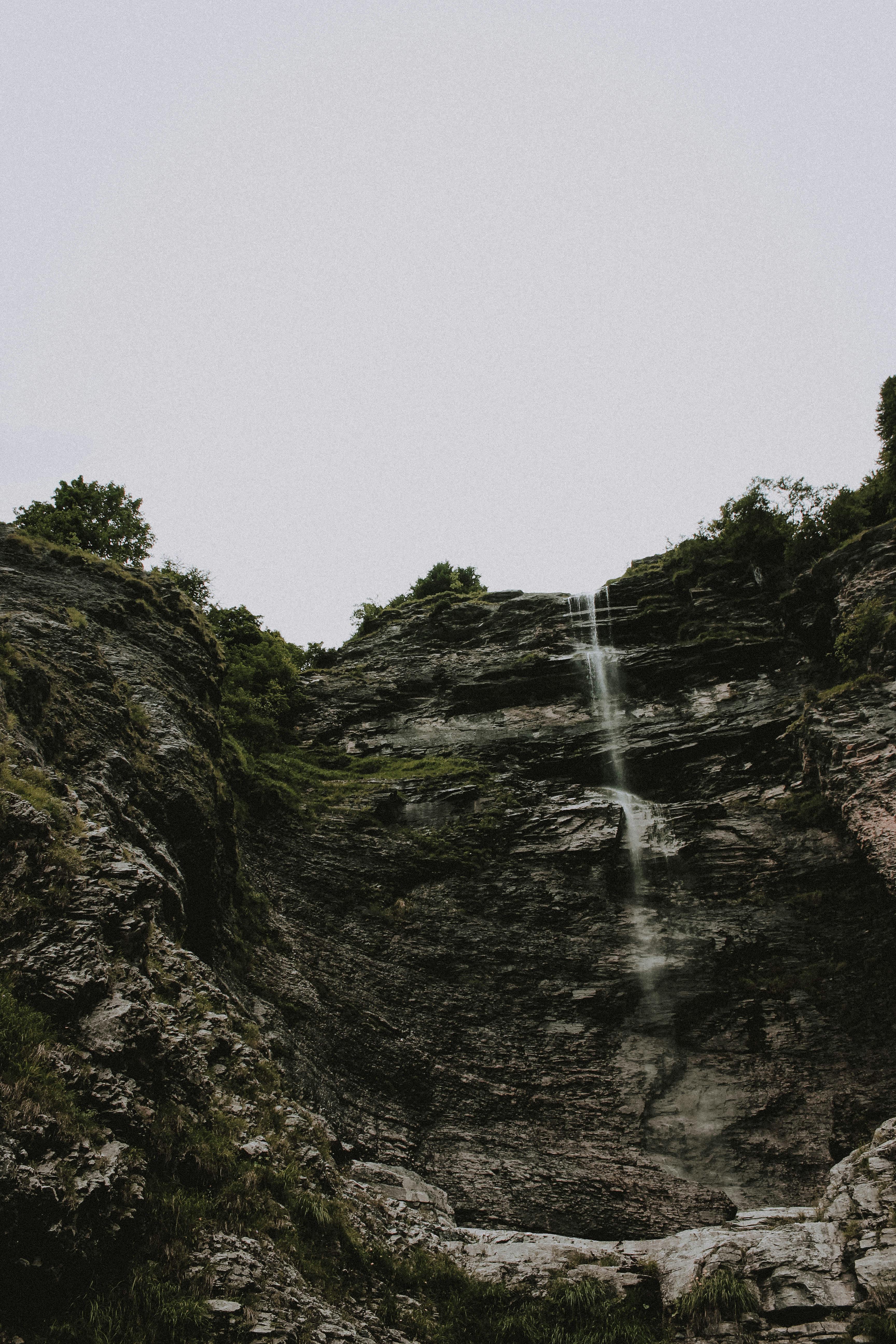 瀑布顺着崎岖的悬崖倾泻而下，令人叹为观止，周围环绕着郁郁葱葱的绿色植物和岩石地层