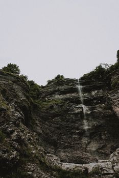 瀑布顺着崎岖的悬崖倾泻而下，令人叹为观止，周围环绕着郁郁葱葱的绿色植物和岩石地层