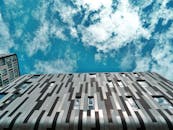 低角度视角下的现代建筑立面，映衬着充满活力的蓝天和云层