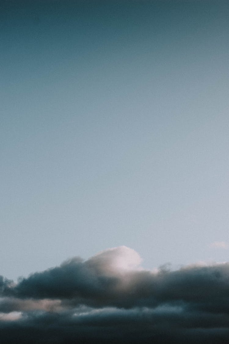 Sun Rays Shining Through Clouds In Blue Sky