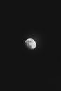 From below of black and white moon in waxing gibbous lunar phase shining in dark night sky