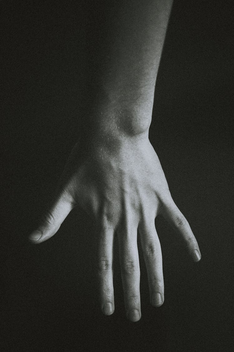 Crop Person Showing Hand Against Black Background