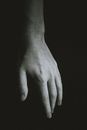 Hand of crop anonymous man against black background