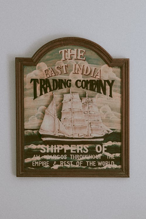 Old fashioned banner of historical trading company with illustration of sailing ship hanging on white wall