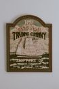 Old fashioned banner of historical trading company with illustration of sailing ship hanging on white wall