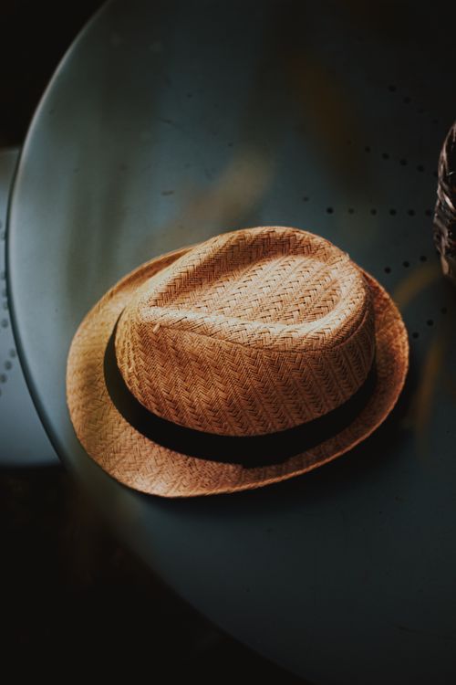 Free From above of stylish yellow straw hat with black ribbon placed on round table in cafe Stock Photo