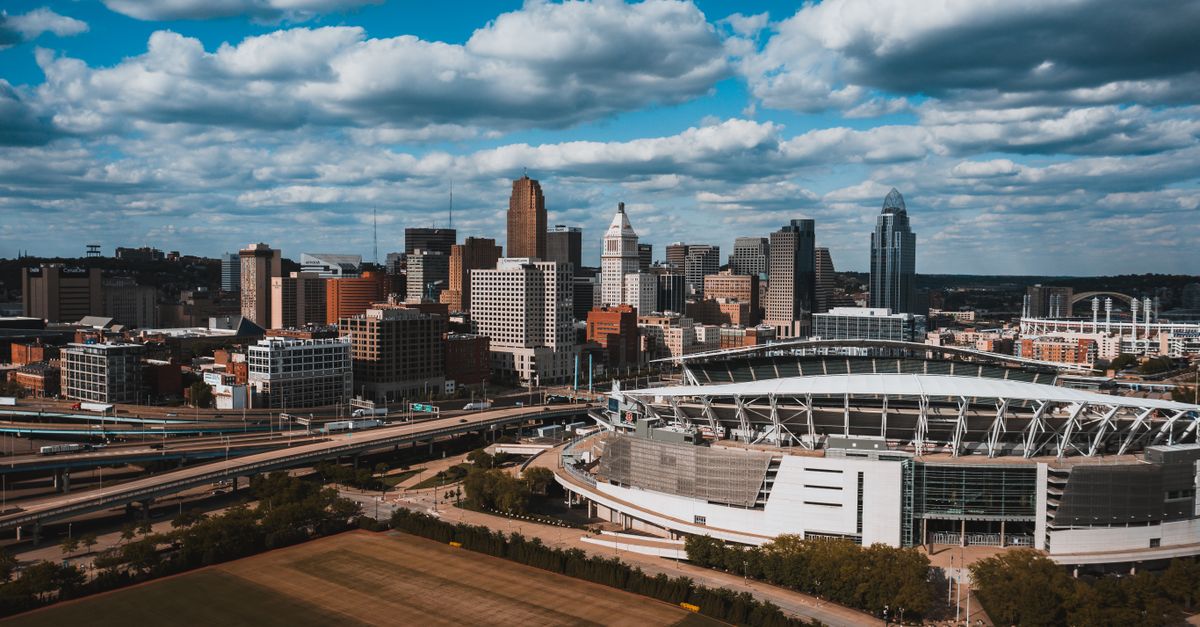 Exterior of large oval Soldier Field surrounded by junction and greenery under sky covered with clouds in Chicago