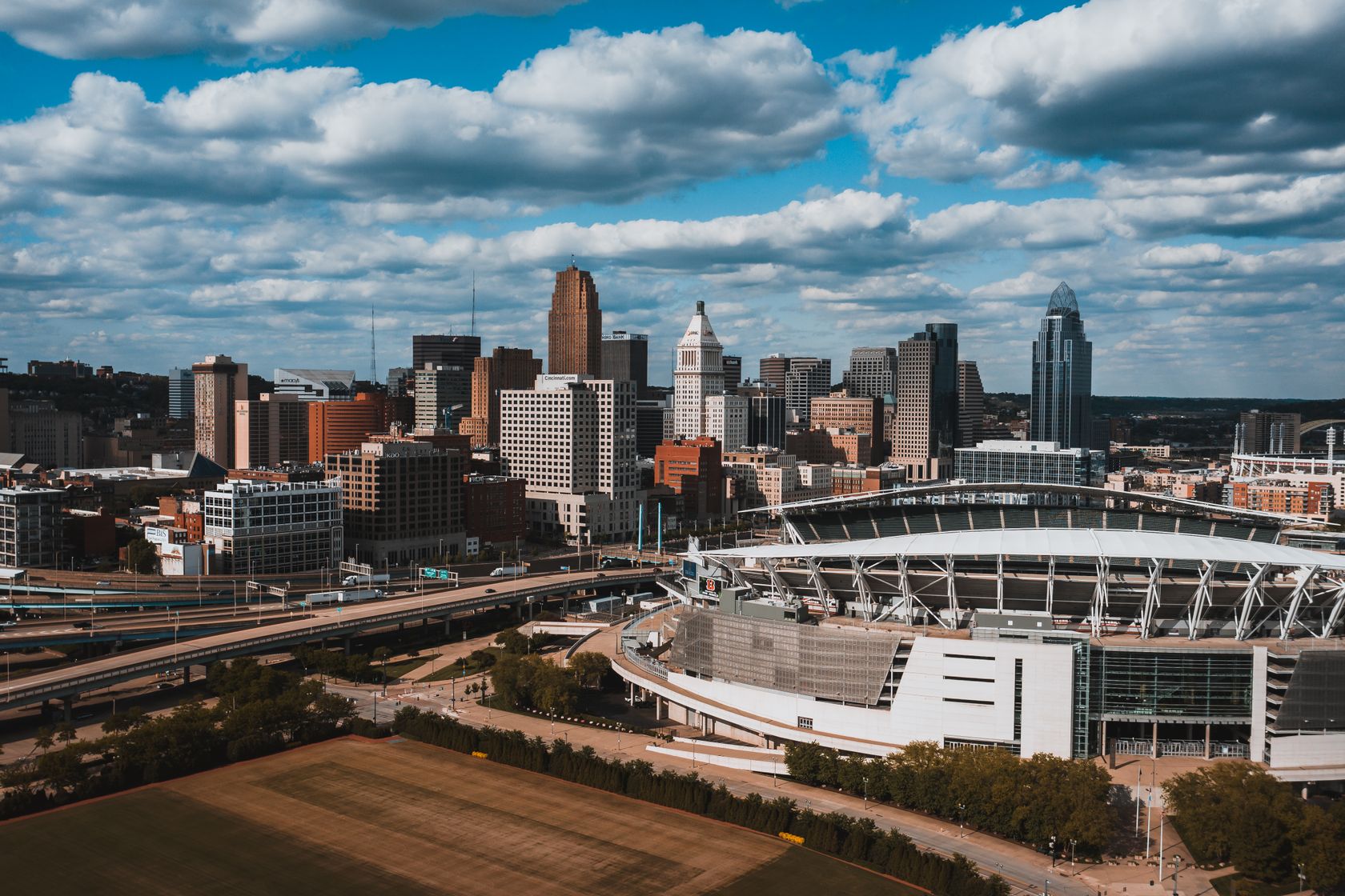 Exterior of large oval Soldier Field surrounded by junction and greenery under sky covered with clouds in Chicago