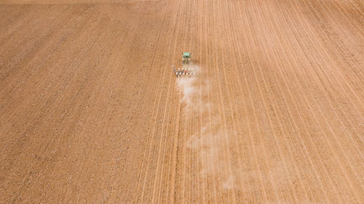 Modern Backhoe Ploughing Agricultural Field