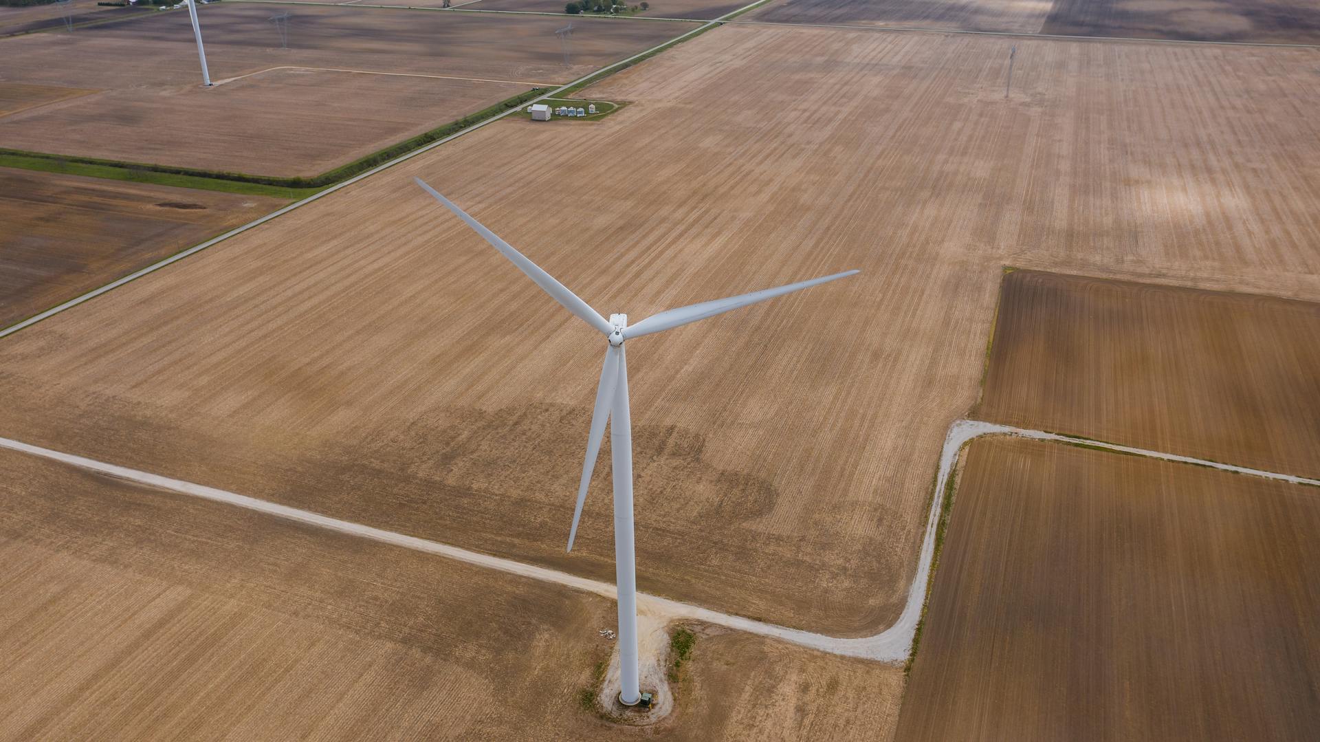 Aerial view of a wind turbine on vast farmland in Tipton, Indiana, showcasing renewable energy.