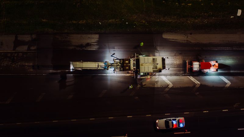 Orange traffic cones and construction barriers narrowing lanes on a city street