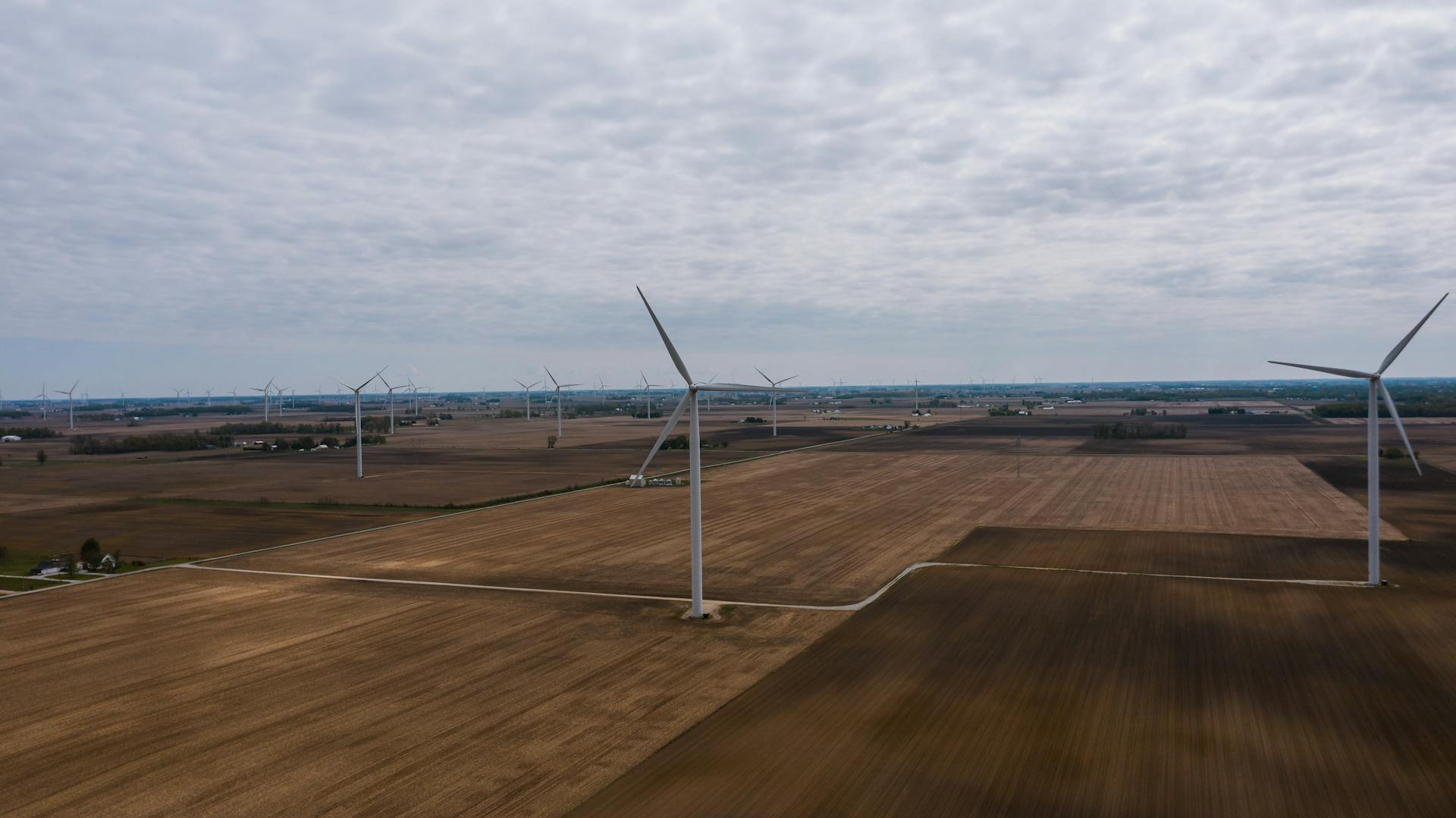 Aerial shot of wind turbines scattered across farmland in Tipton, Indiana, showcasing renewable energy.