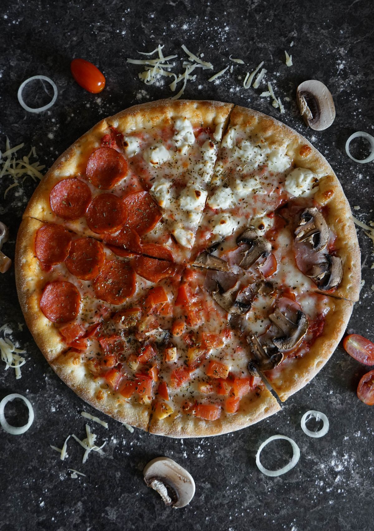 Pizza généreuse à quatre garnitures, vue de dessus sur ardoise