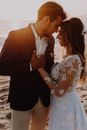 Man in Brown Suit Kissing Woman in White Floral Dress