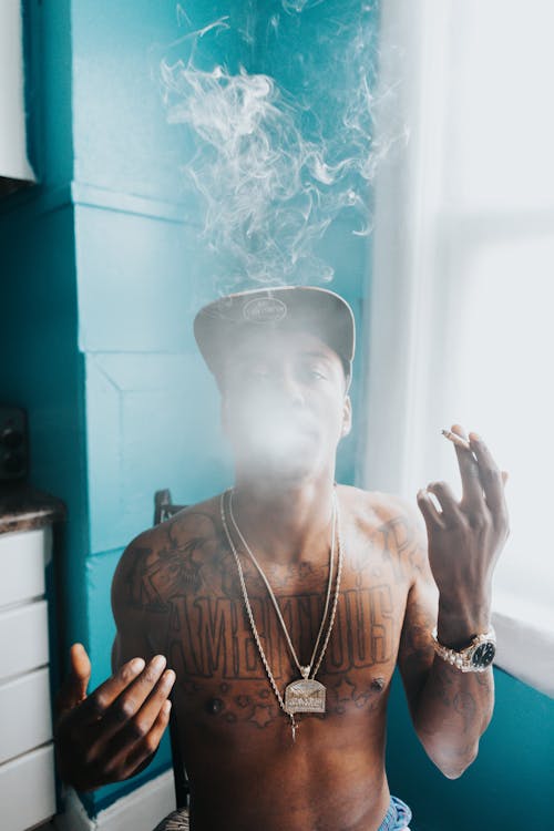 Shirtless Man Smoking with Face Covered with Smoke