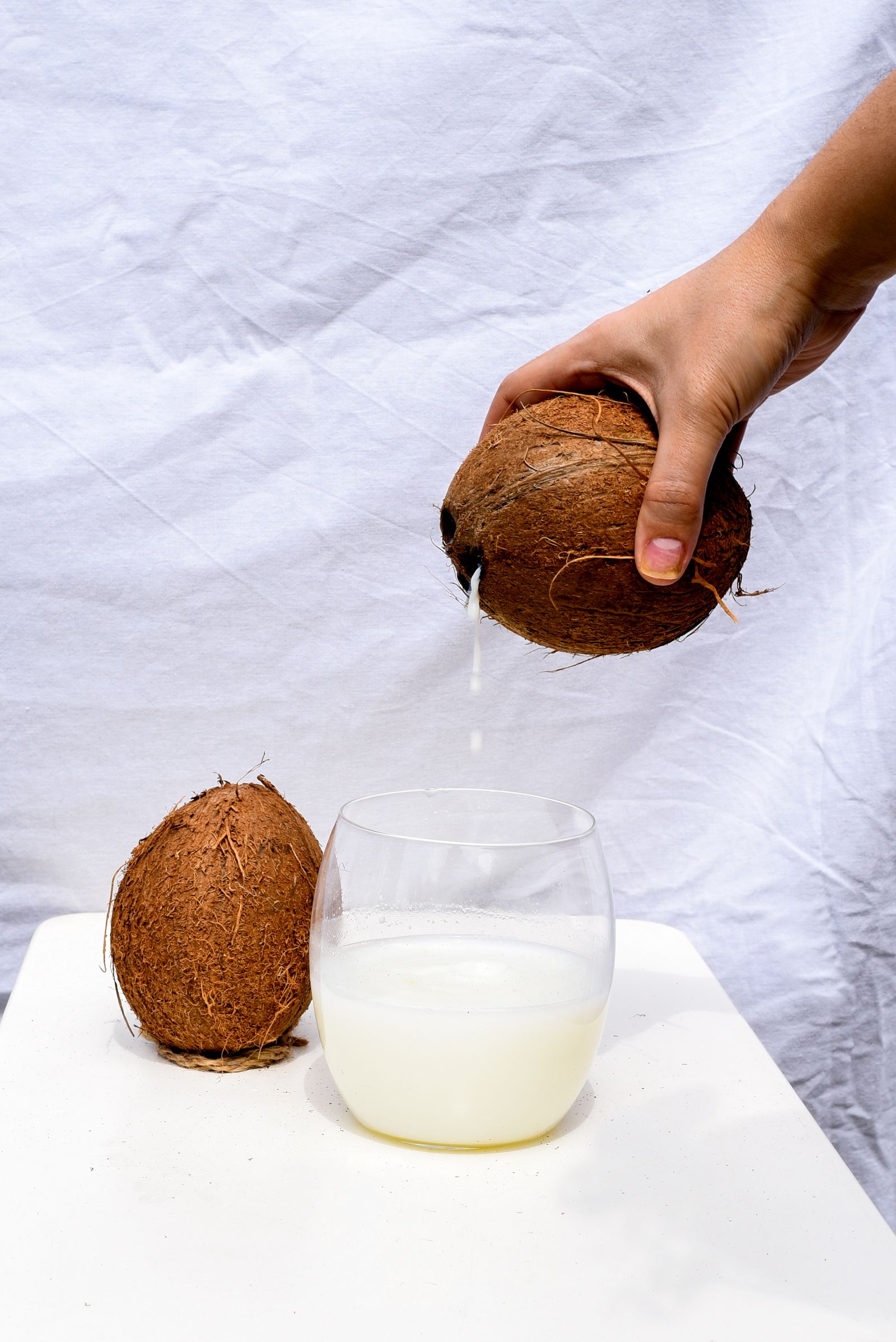 Glass of coconut water with coconut pieces
