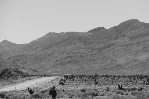 Free Vast desert landscape with a road and mountains in Rachel, Nevada. Stock Photo