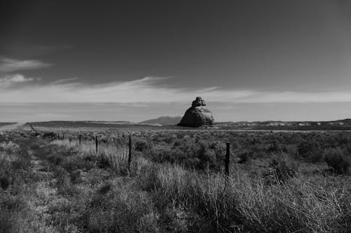 Grayscale Photo of Church Rock in Utah Under Dark Sky