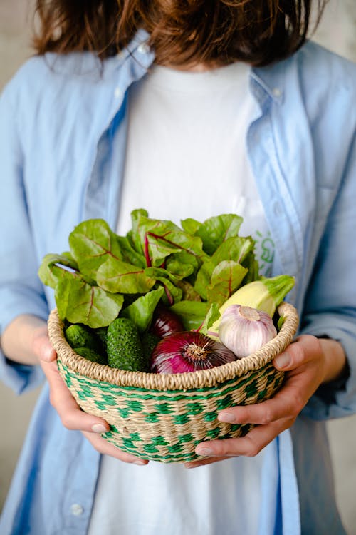 Free Woman Holding a Basket with Vegetables Stock Photo