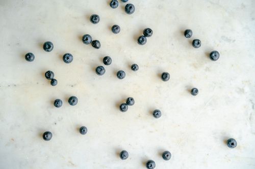 Free Top view of fresh blueberries scattered on a white marble background. Stock Photo