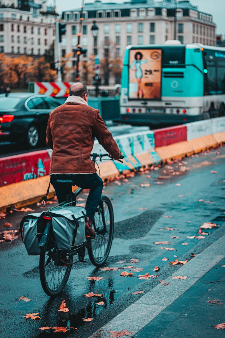 Unrecognizable Male Riding Bicycle With Delivery Bag On Road