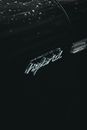 From above of contemporary black hybrid auto with creative title and water droplets on surface