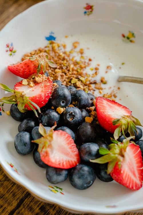 Free Close-up of strawberries and blueberries with granola in a decorative bowl. Stock Photo