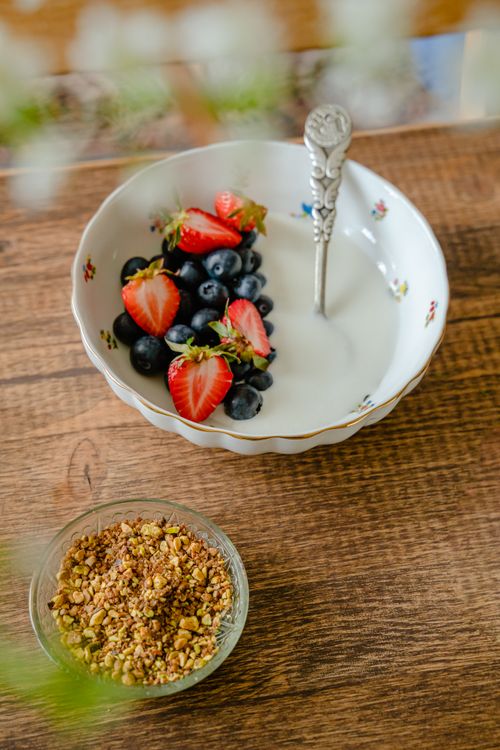 Free A delicious breakfast bowl featuring fresh strawberries and blueberries with milk on a wooden table. Stock Photo