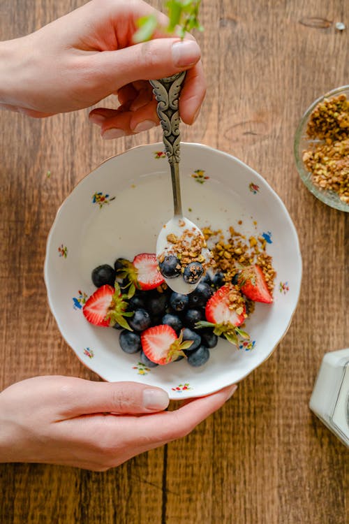 A Hand Holding a Spoon of Cereals