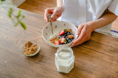 Preparing Fruit Salad with Yogurt and Crushed Peanuts