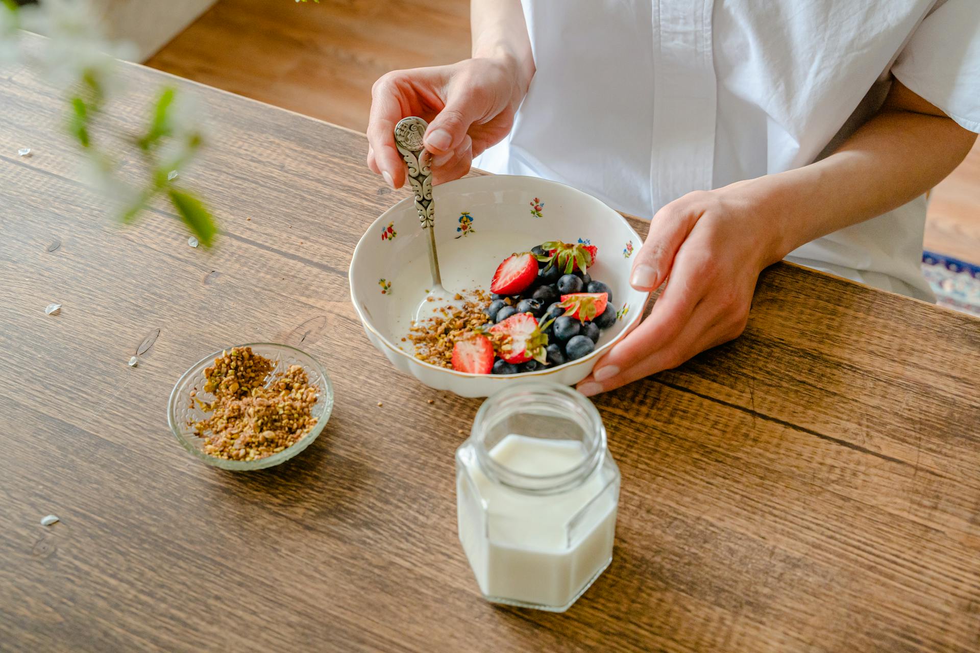 Preparing Fruit Salad with Yogurt and Crushed Peanuts