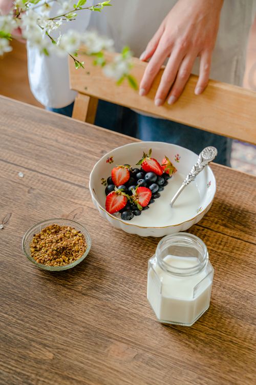 Free A vibrant breakfast bowl with fresh strawberries and blueberries, served with granola and milk. Stock Photo