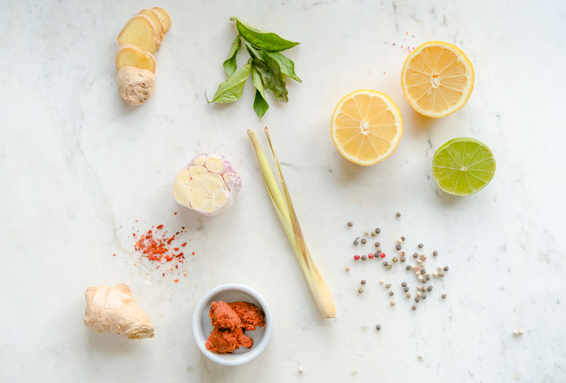 Glass jars filled with freshly made ginger turmeric shots on wooden board