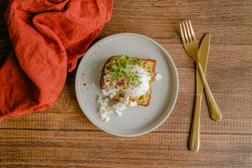 Free Delicious poached egg with feta cheese and microgreens atop toast, elegantly plated. Stock Photo