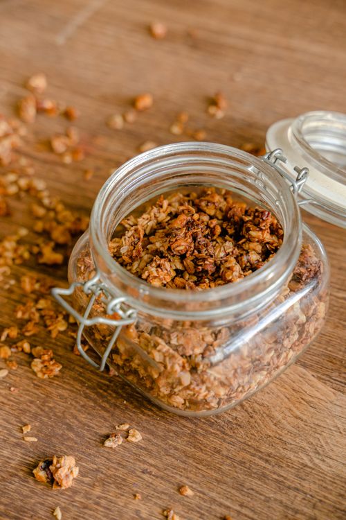 Free Close-up of granola in an open glass jar on a wooden table, emphasizing a healthy lifestyle. Stock Photo
