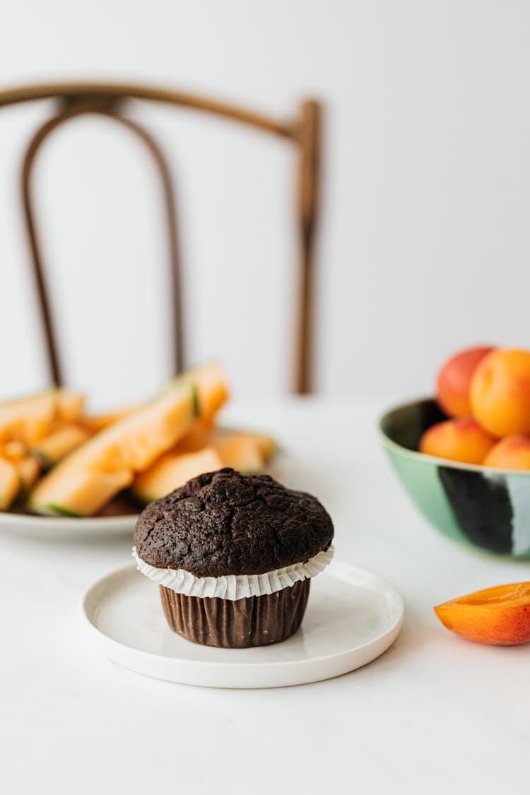 Breakfast Table With Chocolate Cupcake And Fresh Fruits On Background