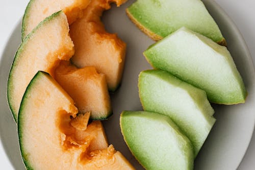 Top view of ripe fresh cantaloupe and honeydew melons cut and served on plate