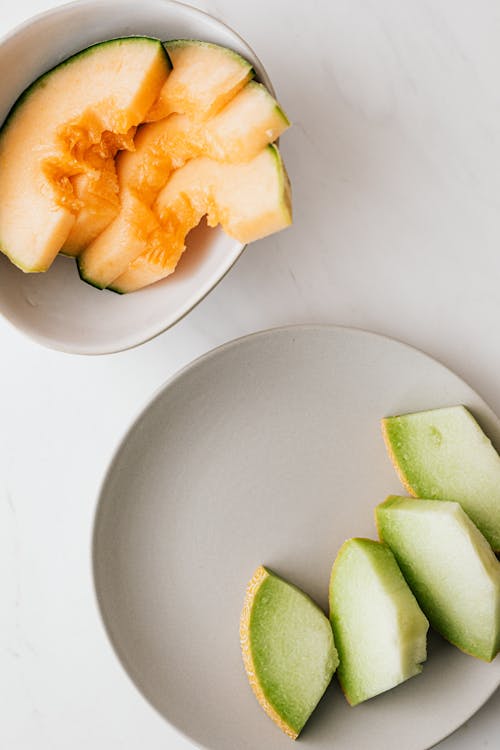 Fresh cut assorted melons served in bowl and plate