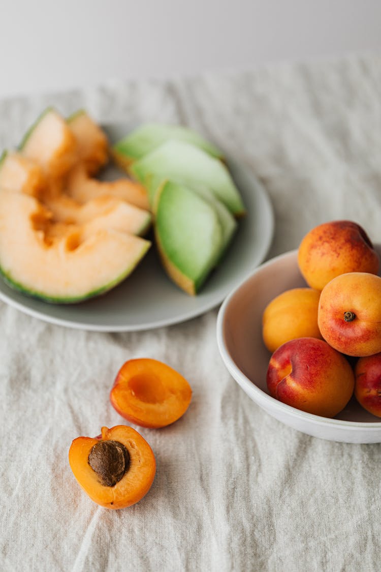 Bowl And Plate Of Fruits On White Surface