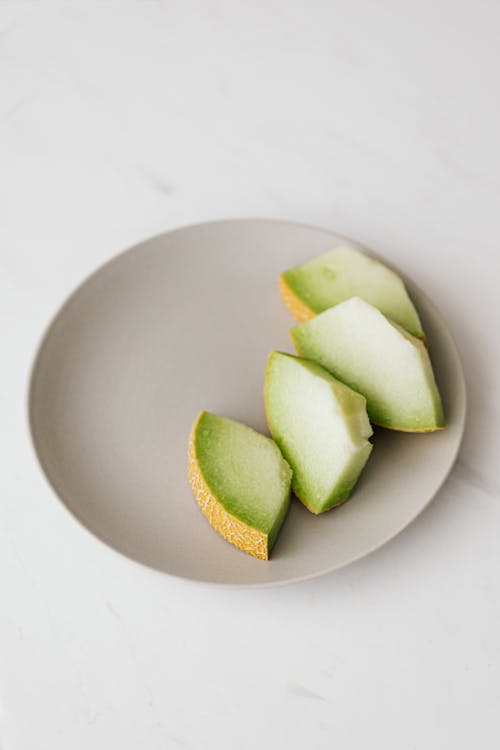 Slices of melon in plate placed on table