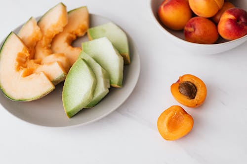 Fresh fruits in bowl and plate on table
